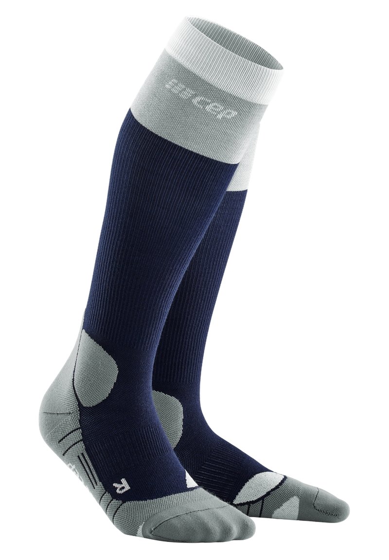 Calze compressive per ginocchio in blu navy e grigio chiaro. Texture a coste, con tallone e punta imbottiti, supporto dell'arco rinforzato e zone in rete traspiranti.