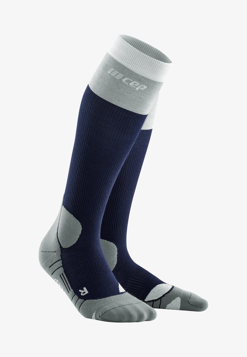 Calze compressive per ginocchio in blu navy e grigio chiaro. Texture a coste, con tallone e punta imbottiti, supporto dell'arco rinforzato e zone in rete traspiranti.