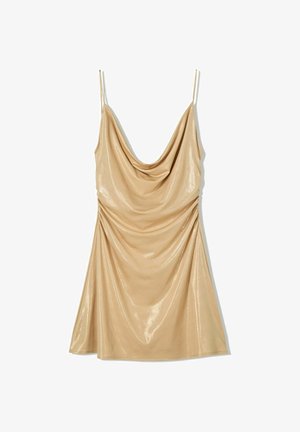 Robe nuisette en satin beige avec un décolleté drapé, de fines bretelles ajustables et des détails froncés sur le côté. Texture lisse et brillante.