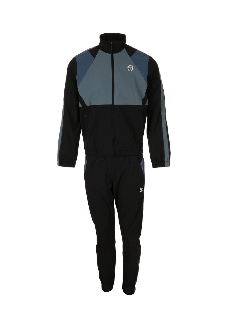 Tuta nera con giacca con zip e pantaloni con vita elastica. La giacca presenta inserti grigi sulle spalle e sui lati con dettagli logo.