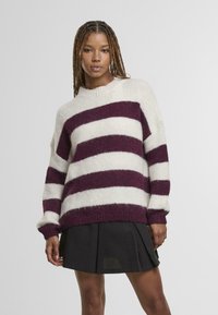 Sweter dziany z grubymi poziomymi paskami w kolorze bordowym i białym, okrągłym dekoltem i luźnym krojem. Miękka tekstura z prążkowanymi mankietami.