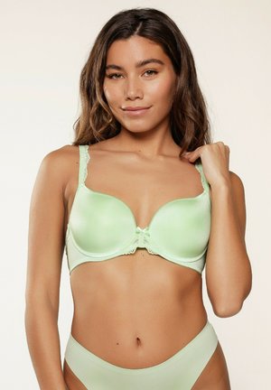Reggiseno imbottito verde chiaro con dettagli in pizzo sulle spalline e sul ferretto. Presenta un fiocco centrale, una texture liscia e coppe rotonde.