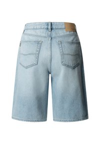 Lichtblauwe denim shorts gezien van achteren met twee opgestikte zakken en een bruin leren merkembleem op de tailleband.