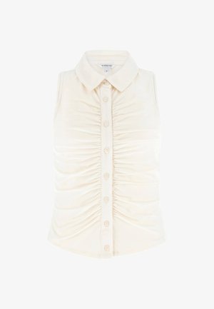 Blouse blanche sans manches à boutons, avec un col pointu et des détails froncés sur le devant.