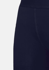 Marineblauwe leggings van een gladde, rekbare stof met een brede tailleband. Stitch-details langs de naden verbeteren de structuur en pasvorm.