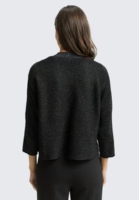 Black textured knitted sweater with a relaxed fit, three-quarter sleeves, and a crew neckline. Subtle metallic thread accents throughout.