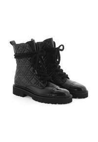 Bottines noires en cuir matelassé avec des embouts en vernis brillant, des lacets texturés et des semelles en caoutchouc épaisses. Présente des languettes à l'arrière.