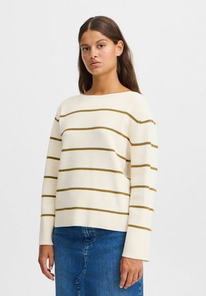 Pull en crème tricoté avec des rayures horizontales vert foncé, décolleté large, manches longues et coupe décontractée, associé à une jupe en denim bleu.
