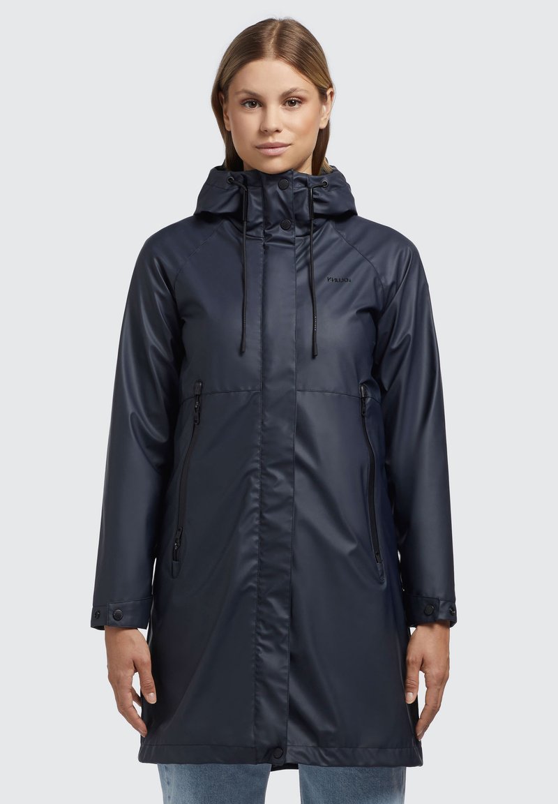 Giacca impermeabile blu navy con zip frontale, cappuccio regolabile e tasche laterali. Presenta una texture liscia e polsini con bottoni.