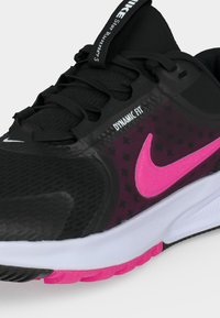 Μαύρο και ροζ παπούτσι για τρέξιμο Nike Star Runner 3 με ροζ σόλα, λευκή μεσαία σόλα, ετικέτα Dynamic Fit και ορατά κορδόνια σε απλό φόντο.
