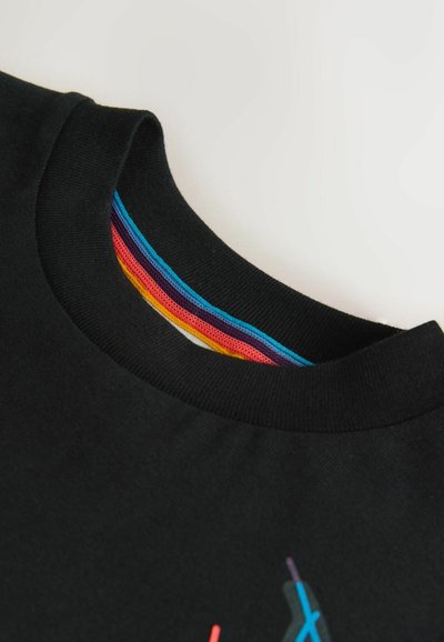 T-shirt noir à col rond avec col côtelé et détail coloré à rayures arc-en-ciel à l'intérieur du col, sur fond blanc.