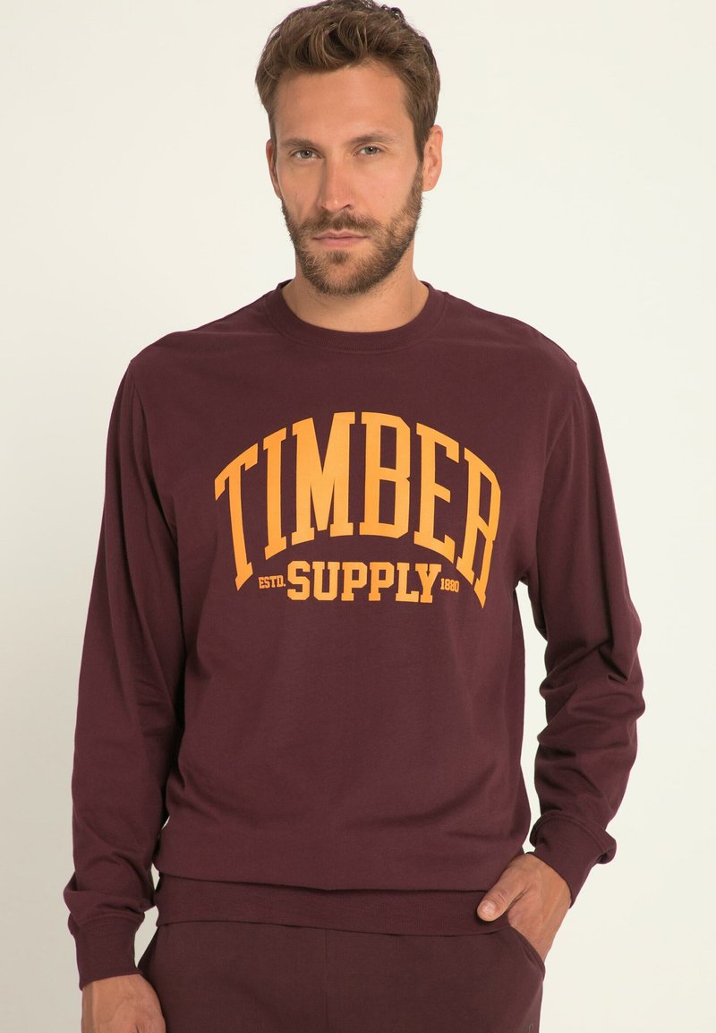 Bordowy długi rękaw sweatshirt z dużym żółtym napisem "TIMBER SUPPLY". Miękki materiał, luźny krój i ribbated dekolt.