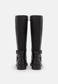 Czarne kozaki sięgające kolan, wykonane ze skóry, z teksturowanymi panelami, regulowanymi klamrami i grubym obcasem. Charakteryzują się połyskiem i zaokrąglonym kształtem.