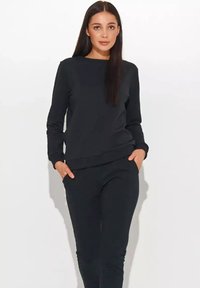 Czarna bluza i pasujące spodnie wykonane z miękkiego materiału, z dekoltem w serek i bocznymi kieszeniami, w luźnym kroju.