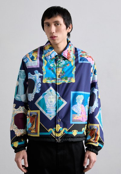 Veste rembourrée colorée avec un imprimé bleu et marine et des motifs d'art classique, boutons sur le devant et poignets en élasthanne texturé.