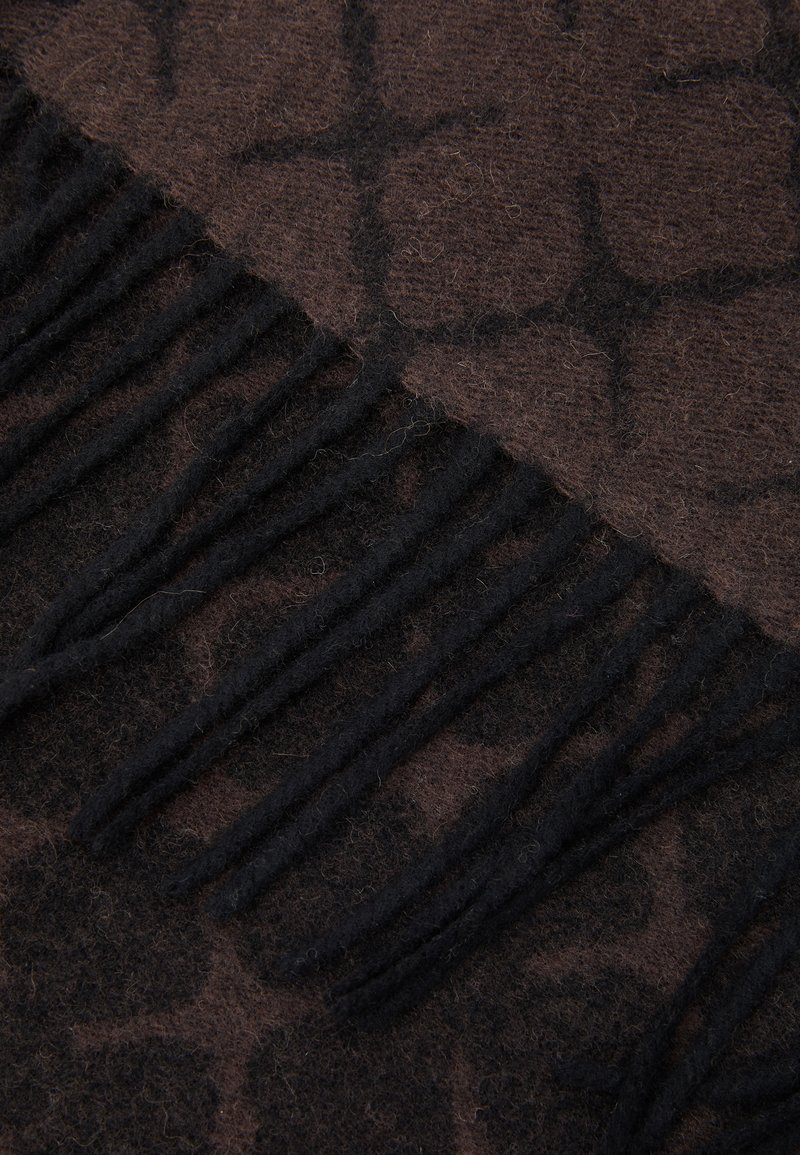 Brun mönstrad halsduk med en mjuk textur, fransdetaljer och en kontrasterande mörkare brun design. Materialet verkar vara ull eller ett liknande tyg.