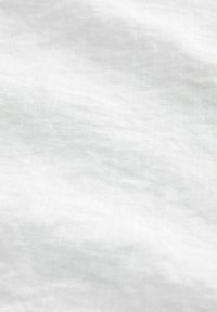 Fond en tissu blanc texturé avec des plis subtils et une surface douce, légèrement irrégulière.