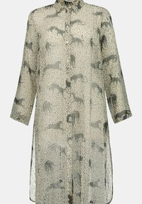 Robe-chemise beige transparente avec une patte de boutonnage à l'avant, ornée d'imprimés animaliers noirs et d'un motif texturé. Manches longues et fentes latérales pour un design amélioré.