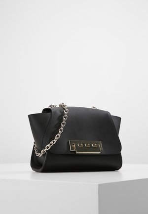 Schwarze Lederhandtasche mit goldenem rechteckigem Verschluss und silberner Kette, präsentiert auf einem weißen Sockel vor einem schlichten Hintergrund.