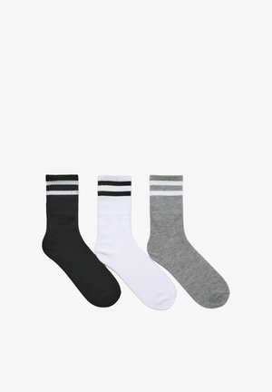 Tre paia di calze: una nera con righe bianche, una bianca con righe nere e una grigia. Tutte sono di lunghezza crew e con una texture liscia.