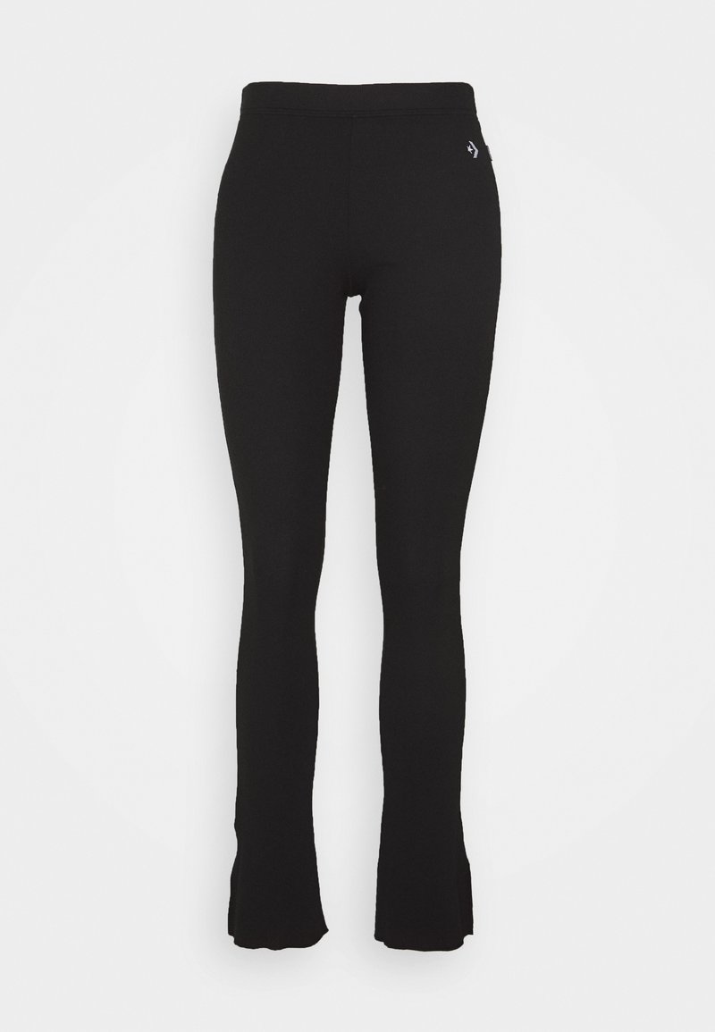 Svart utsvängda leggings i elastiskt tyg. Har ett hög midja och en diskret logotypdetalj på höften. Slät textur genomgående.