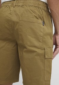 Olivengrønne cargo-shorts lavet af bomuld, med elastisk talje, sidelommer og en standard baglomme med logomærke.