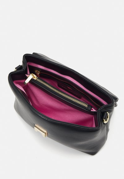 Borsa a mano in pelle nera con una chiusura in oro lucido. L'interno presenta una fodera rosa brillante e una tasca con zip, offrendo contrasto e funzionalità.