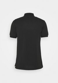 Černé polo tričko s krátkým rukávem a límečkem, zobrazené ze zadní strany, s malým černým logem Nike pod límečkem.