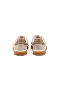 Scarpe in suede beige con forma arrotondata, dotate di una suola in gomma marrone chiaro e dettagli bianchi, progettate con un morbido tassello sul tallone.