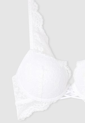 Reggiseno in pizzo bianco con coppe imbottite, bordi ondulati e dettagli incrociati sulle spalle sul retro, realizzato in un tessuto morbido e texturizzato.