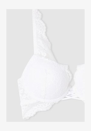 Reggiseno in pizzo bianco con coppe imbottite, bordi ondulati e dettagli incrociati sulle spalle sul retro, realizzato in un tessuto morbido e texturizzato.