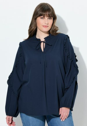 Marineblaue Bluse aus weichem Stoff mit Rüschendetails an den Ärmeln und einem Schlüsselloch-Ausschnitt. Lange Ärmel mit gerafften Manschetten.