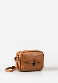 Tan leather bag with a zip closure, front flap, and a small toggle clasp. Features a detachable shoulder strap and smooth texture.