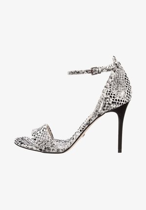 Sandale à talons hauts avec un motif serpent noir et blanc, bout ouvert, bride de cheville réglable et talon aiguille noir brillant.