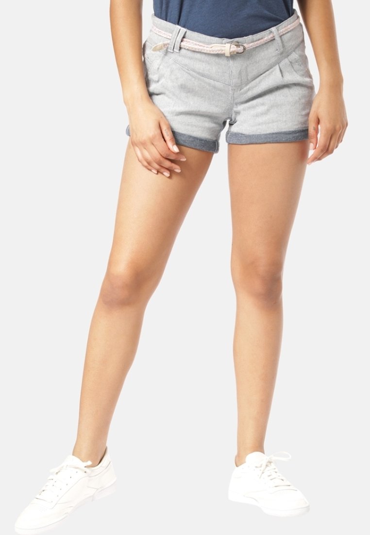 Šedé šortky s ohrnutým lemem, vyrobené z měkkého materiálu. Mají přední sklady a světlý tkaný pásek. S kombinací bílých tenisek.