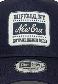 Marineblaue Mütze mit einem gestickten weißen Patch, auf dem "Buffalo, NY" und "New Era" steht. Verstellbar mit einem runden Etikett auf dem Schirm.