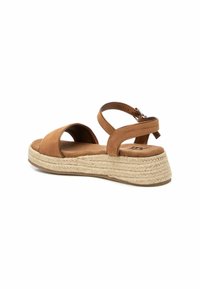 Sandalias de cuña de ante marrón con una plataforma de yute trenzado. Presenta una correa ancha y una correa de tobillo ajustable para un ajuste seguro.
