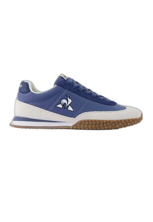 Blue and white low-top sneaker with gum rubber sole, blue laces, and a white rooster logo on the side facing right.