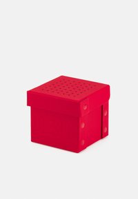 Rotes Quadratbox aus strukturiertem Material mit perforiertem Deckel und erhabenem "DIESEL"-Logo an der Seite. Verstärkte Ecken mit kreisförmigen Details.