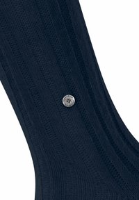 Calzino in tessuto lavorato a maglia blu navy con un motivo testurizzato e un accento di logo rotondo argentato sul lato. Materiale liscio con una forma aderente.