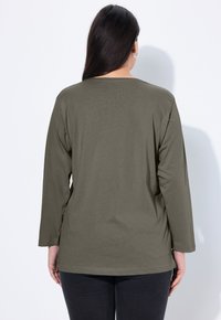 Olive green long-sleeve T-shirt with a relaxed fit. Soft fabric with a round neckline and slightly curved hem, shown from the back.