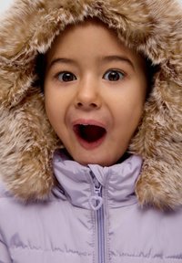 Jasnofioletowa kurtka typu puchówka z futrzanym kapturem. Posiada zip w kształcie serca oraz miękką, teksturowaną powierzchnię.