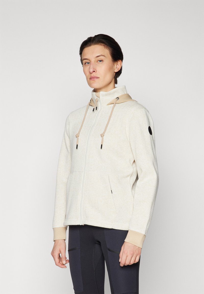 Cream herringbone zip-up jacket with a beige hood, adjustable drawstrings, front pockets, and black logo detail on sleeve.
