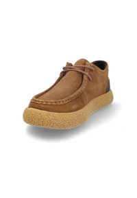 Zapato de ante marrón con puntera redondeada, que presenta una suela de goma texturizada y un lazo de cuero decorativo en la parte superior. Acabado de tacón negro.