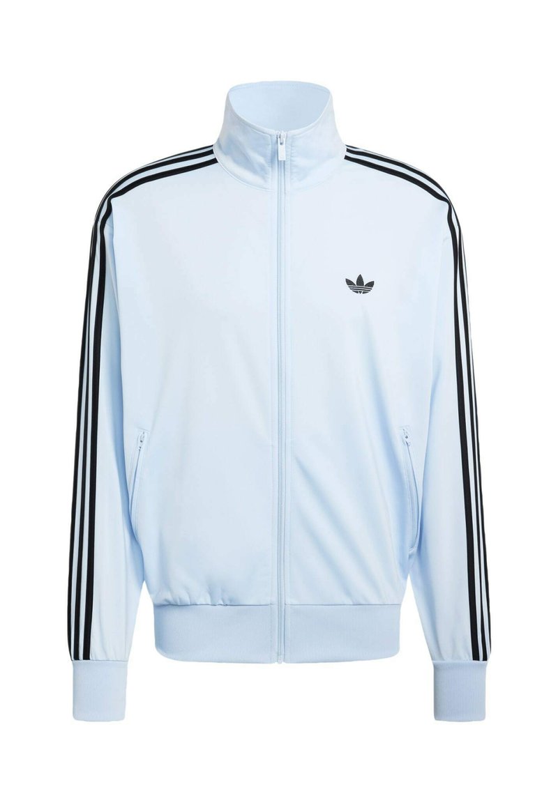 Giacca da allenamento azzurro chiaro con zip, con tre strisce nere Adidas sulle maniche e logo trefoil nero sul petto a sinistra.