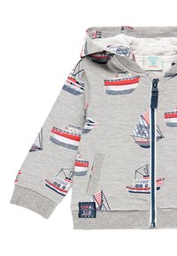 Grey hooded sweatshirt with a zip closure, featuring a boat print in red and blue. Notable details include a tag with "CORAL SEA."