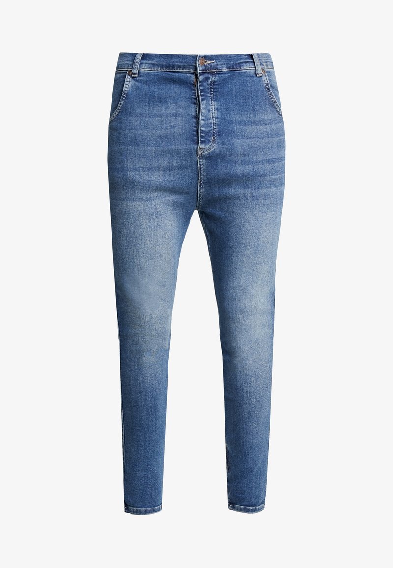 Jean bleu slim avec poches avant, passants pour ceinture et fermeture à bouton, présentant un effet délavé sur les cuisses et les genoux.