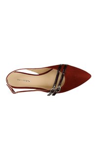 Scarpa rossa in suede con punta affusolata e due cinturini neri lucidi con hardware decorativo. Design con apertura sul tallone, fodera interna liscia e stile minimalista.