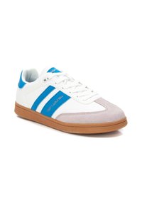 Sneaker bianca con strisce blu e punta in suede grigio, dotata di una tomaia texturizzata e una suola in gomma naturale. Lacci per una vestibilità sicura.