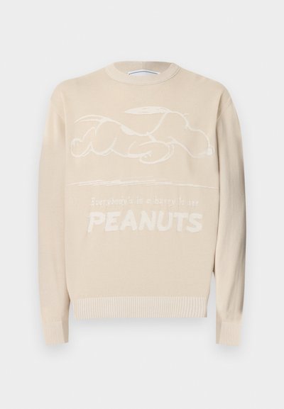 Μπεζ πουλόβερ με ανάγλυφο σχέδιο Snoopy και κείμενο «Everybody's in a happy la see PEANUTS» στο μπροστινό μέρος, με ριμπ μανσέτες και τελείωμα.